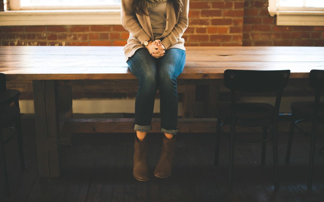 Woman in brown boots sitting on table