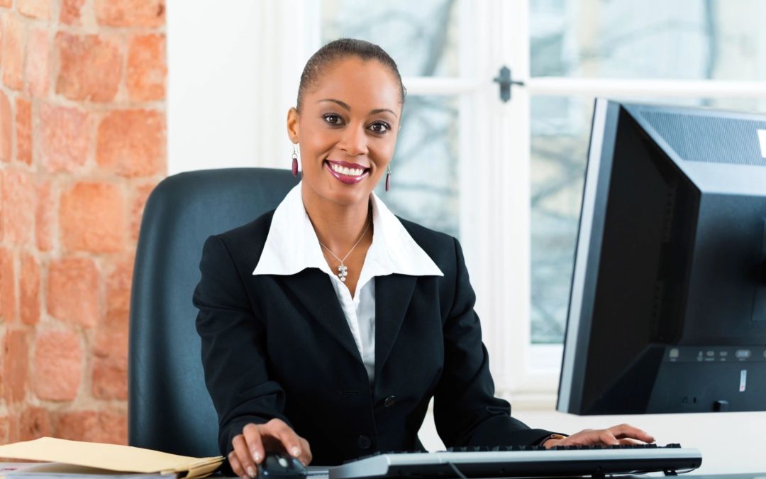 Woman leader in black business suit sitting at desk
